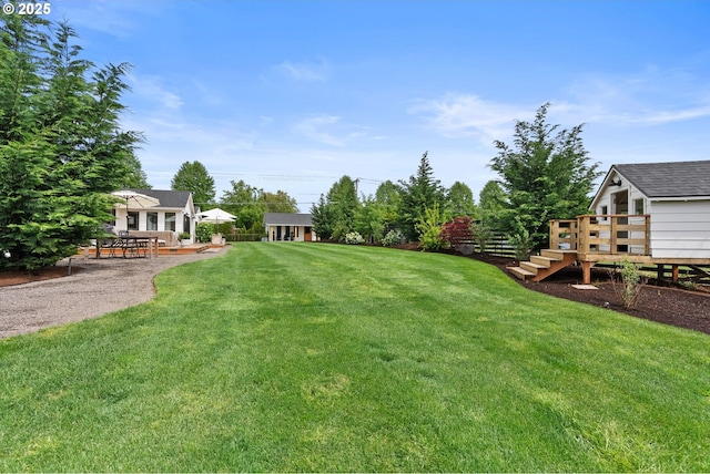 view of yard featuring a patio, a wooden deck, and stairway