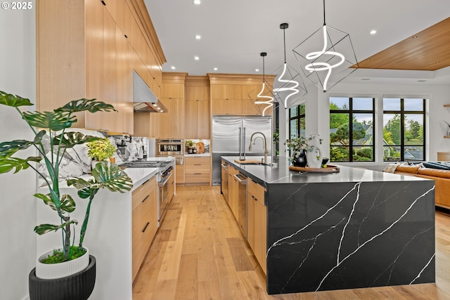 NE 43rd Cir Lot 5, Camas, WA 98607 - kitchen with under cabinet range hood, appliances with stainless steel finishes, light brown cabinets, modern cabinets, and light wood-style floors