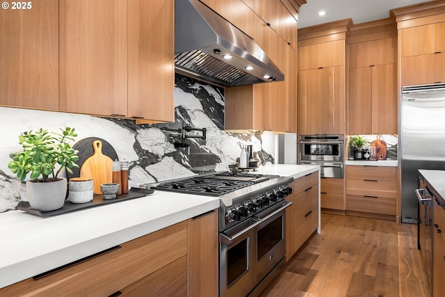 NE 43rd Cir Lot 5, Camas, WA 98607 - kitchen featuring premium appliances, wall chimney exhaust hood, modern cabinets, tasteful backsplash, and recessed lighting