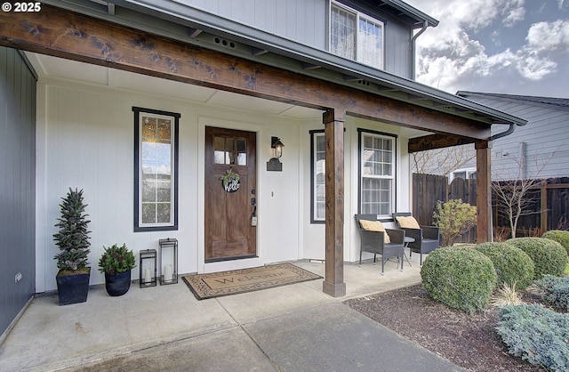 entrance to property featuring fence and covered porch