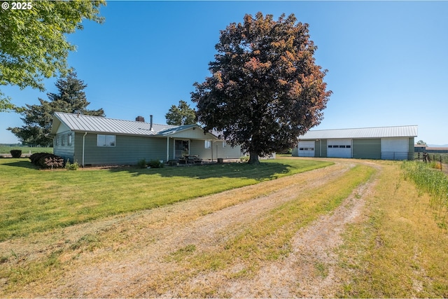 ranch-style house with driveway, a front lawn, a garage, metal roof, and a chimney