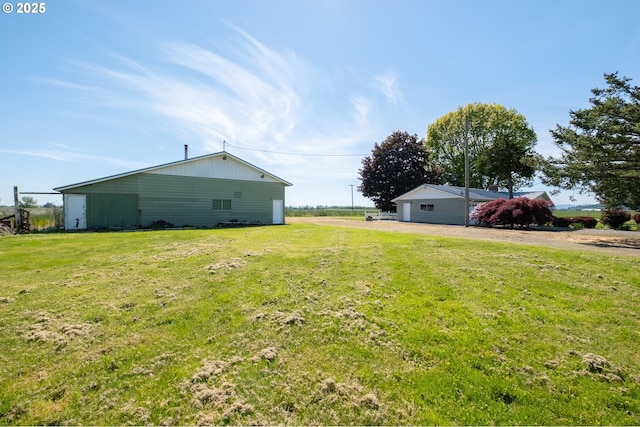 view of grassy yard featuring a garage and driveway