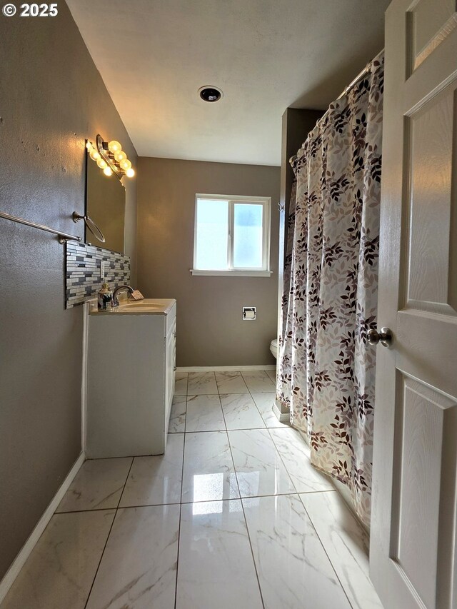 bathroom featuring vanity, backsplash, and toilet