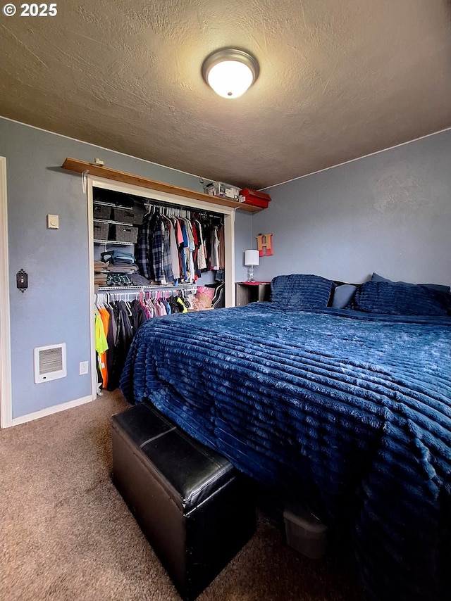 carpeted bedroom with a textured ceiling and a closet