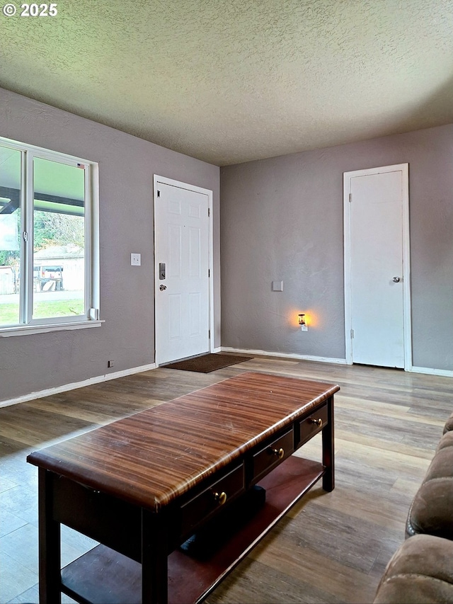 living room with a textured ceiling and light wood-type flooring