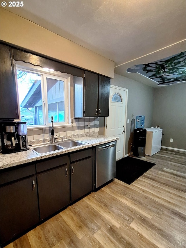 kitchen featuring sink, dishwasher, dark brown cabinetry, tasteful backsplash, and light wood-type flooring