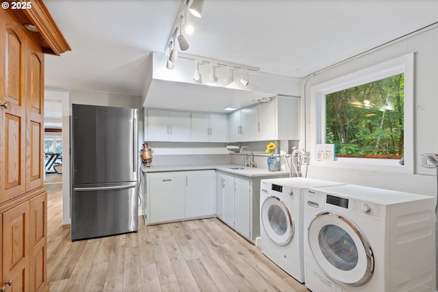 2245 SW Martha St, Portland, OR 97239 - laundry area featuring washer and clothes dryer, rail lighting, light wood finished floors, and plenty of natural light