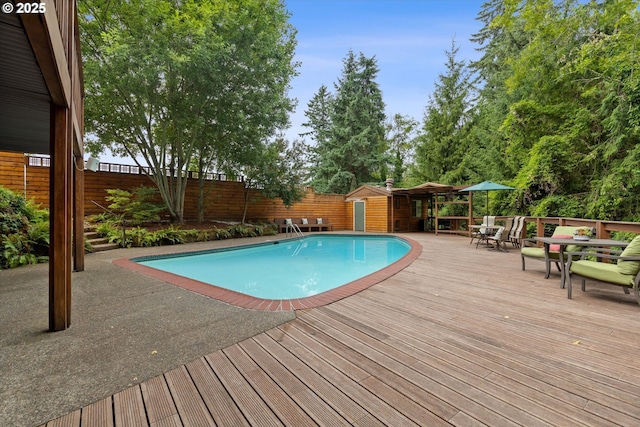 2245 SW Martha St, Portland, OR 97239 - view of pool with outdoor dining area, a fenced backyard, a wooden deck, and a shed