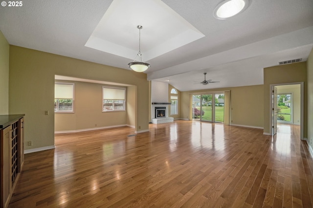 533 Fountain Ct, Keizer, OR 97303 - unfurnished living room with wood finished floors, healthy amount of natural light, a tray ceiling, and a brick fireplace