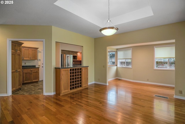 533 Fountain Ct, Keizer, OR 97303 - unfurnished living room with dark wood-style flooring, a skylight, and a tray ceiling
