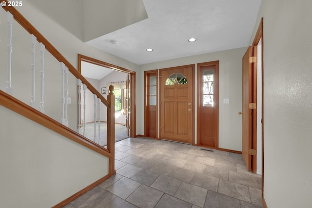 foyer entrance featuring baseboards, recessed lighting, visible vents, and stairway