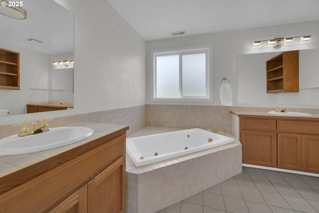 full bath with visible vents, a sink, tile patterned floors, and a tub with jets