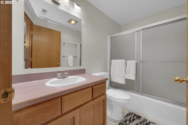 bathroom with toilet, visible vents, combined bath / shower with glass door, and vanity