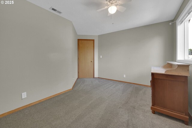 empty room featuring baseboards, light carpet, a ceiling fan, and visible vents
