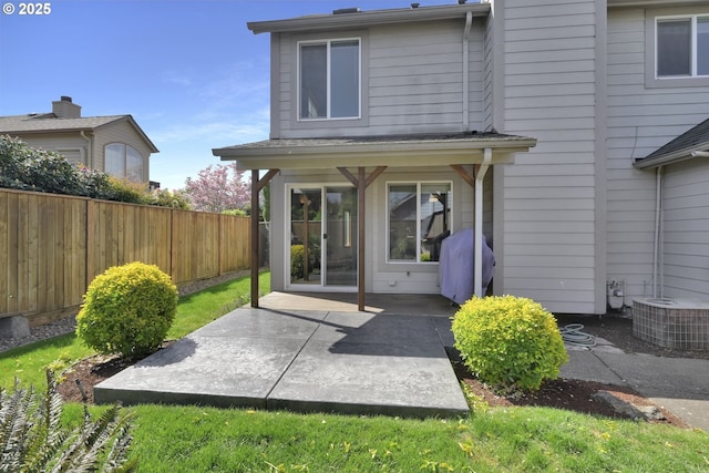 rear view of house with a patio, fence, and central AC unit