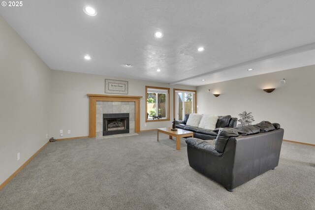 living area with recessed lighting, baseboards, light carpet, and a tiled fireplace