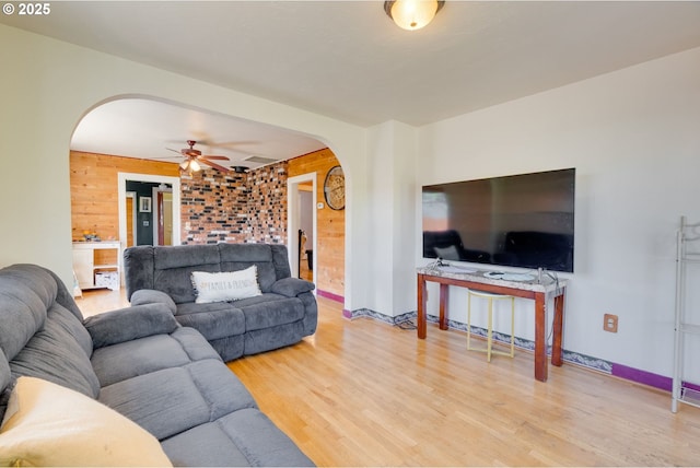 3265 SW 187th Ave, Beaverton, OR 97003 - living room with arched walkways, light wood finished floors, a ceiling fan, and wooden walls