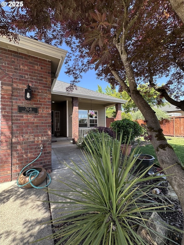 doorway to property with fence and brick siding