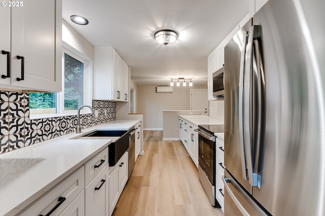 5120 Talisman St, Eugene, OR 97405 - kitchen with stainless steel appliances, a sink, decorative backsplash, light wood-style flooring, and a wall mounted air conditioner