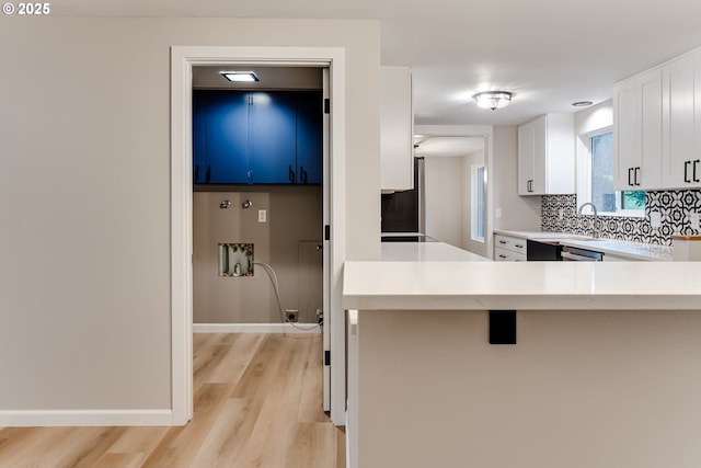 5120 Talisman St, Eugene, OR 97405 - kitchen with light wood-type flooring, light countertops, white cabinets, tasteful backsplash, and a kitchen bar
