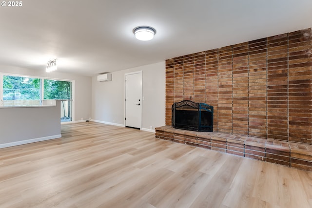5120 Talisman St, Eugene, OR 97405 - unfurnished living room with a wall unit AC, a brick fireplace, wood finished floors, and baseboards