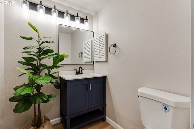 5120 Talisman St, Eugene, OR 97405 - half bathroom with toilet, baseboards, vanity, and wood finished floors
