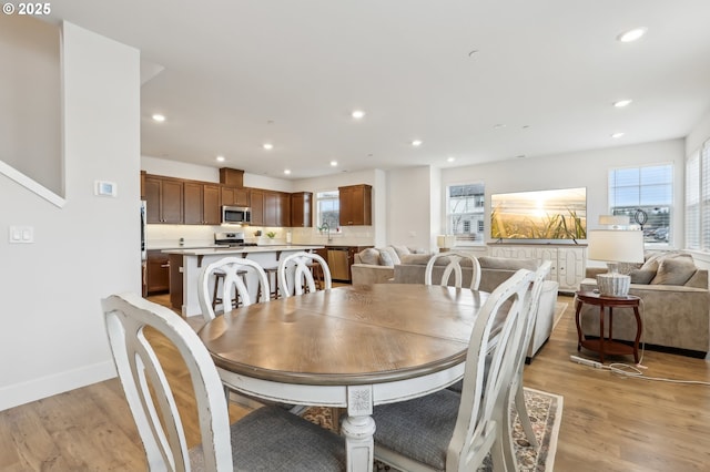 dining space with light hardwood / wood-style floors and sink