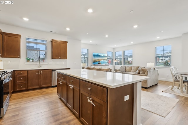 kitchen featuring a center island, sink, stainless steel appliances, and light hardwood / wood-style flooring