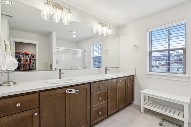 bathroom with tile patterned flooring, vanity, and a shower with door