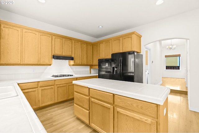 5274 NW Crady Ln, Portland, OR 97229 - kitchen featuring black appliances, light wood-style flooring, arched walkways, recessed lighting, and ventilation hood