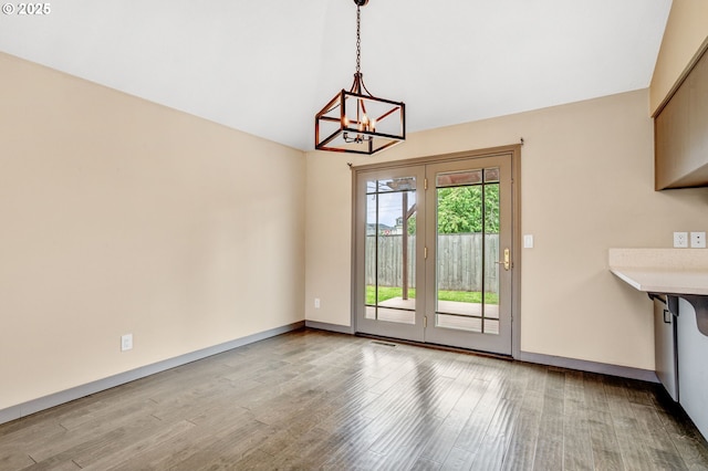 3017 SE Brookwood Ave, Hillsboro, OR 97123 - unfurnished dining area featuring wood finished floors, a chandelier, vaulted ceiling, and baseboards