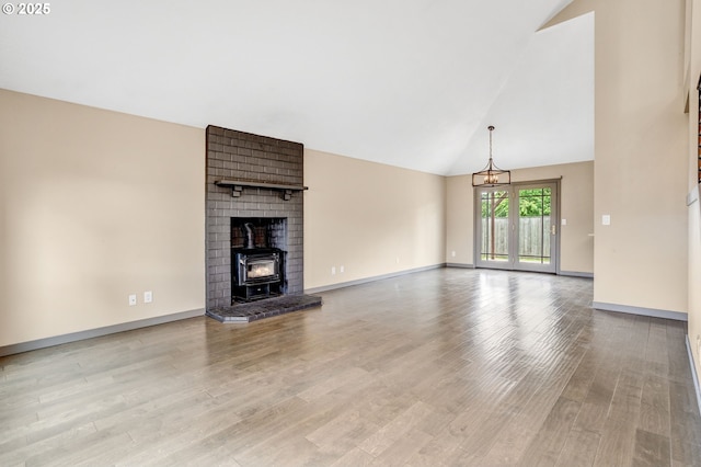 3017 SE Brookwood Ave, Hillsboro, OR 97123 - unfurnished living room featuring high vaulted ceiling, wood finished floors, a wood stove, and baseboards