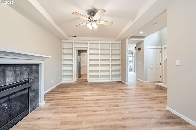 799 NE 70th Ave, Hillsboro, OR 97124 - unfurnished living room with a ceiling fan, a fireplace, baseboards, light wood-style flooring, and built in features