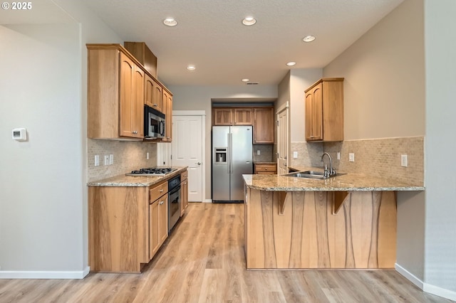 799 NE 70th Ave, Hillsboro, OR 97124 - kitchen with stainless steel appliances, a sink, a peninsula, light wood-style floors, and recessed lighting