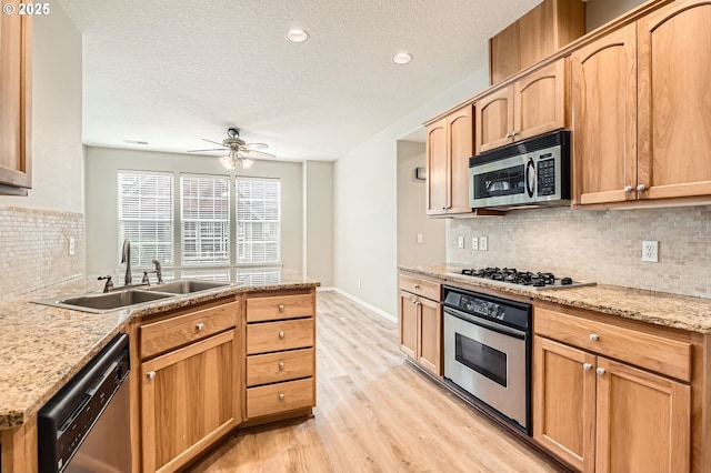 799 NE 70th Ave, Hillsboro, OR 97124 - kitchen with appliances with stainless steel finishes, a sink, light wood-style floors, a textured ceiling, and ceiling fan