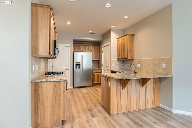 799 NE 70th Ave, Hillsboro, OR 97124 - kitchen with stainless steel appliances, a sink, a peninsula, light wood-style flooring, and recessed lighting