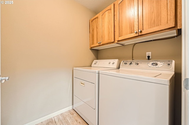 799 NE 70th Ave, Hillsboro, OR 97124 - laundry room with cabinet space, washing machine and dryer, light wood-style floors, and baseboards