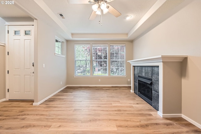 799 NE 70th Ave, Hillsboro, OR 97124 - unfurnished living room featuring ceiling fan, a tile fireplace, light wood-type flooring, a raised ceiling, and baseboards