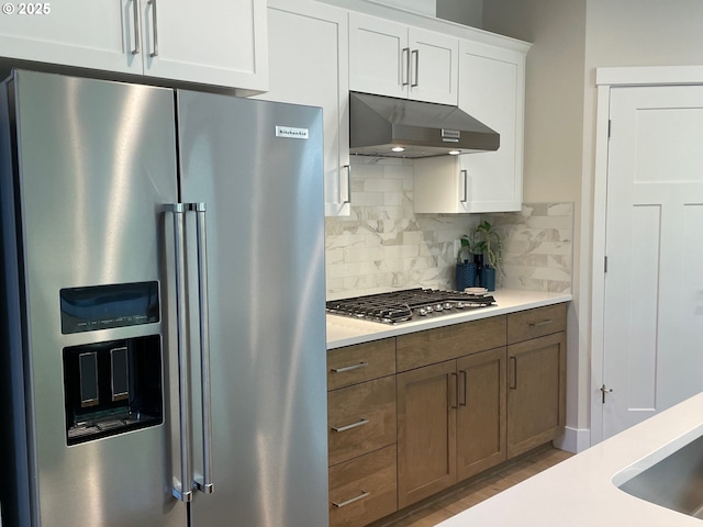 7839 SW Thornbridge Ter Unit 10, Beaverton, OR 97007 - kitchen with stainless steel appliances, under cabinet range hood, backsplash, light countertops, and white cabinets