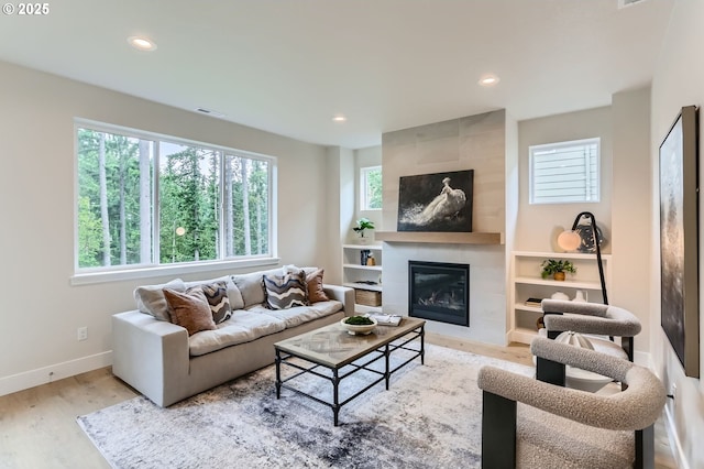 7839 SW Thornbridge Ter Unit 10, Beaverton, OR 97007 - living area featuring wood finished floors, a tiled fireplace, recessed lighting, baseboards, and built in features