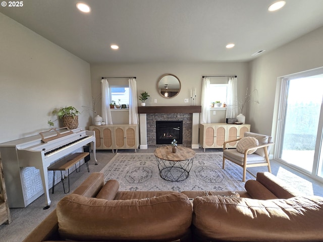 living room featuring light carpet, a fireplace, and a wealth of natural light