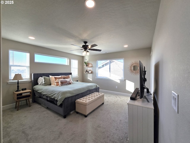 carpeted bedroom featuring ceiling fan and a textured ceiling