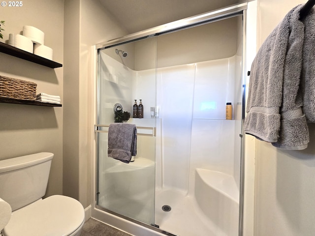 bathroom with toilet and an enclosed shower