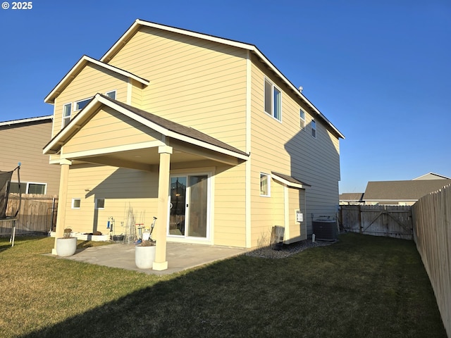 back of house featuring cooling unit, a patio, and a lawn