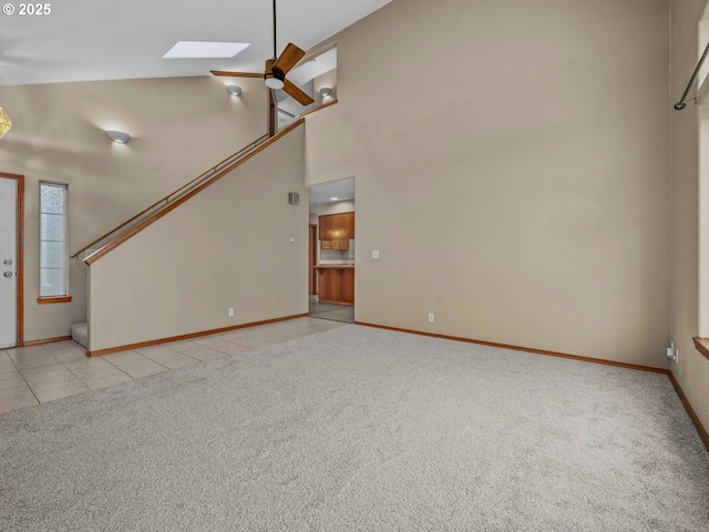 unfurnished living room featuring light colored carpet, high vaulted ceiling, baseboards, and a ceiling fan