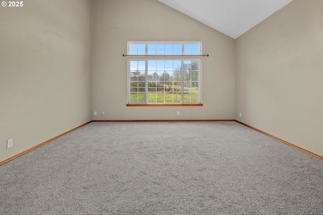 carpeted spare room with high vaulted ceiling