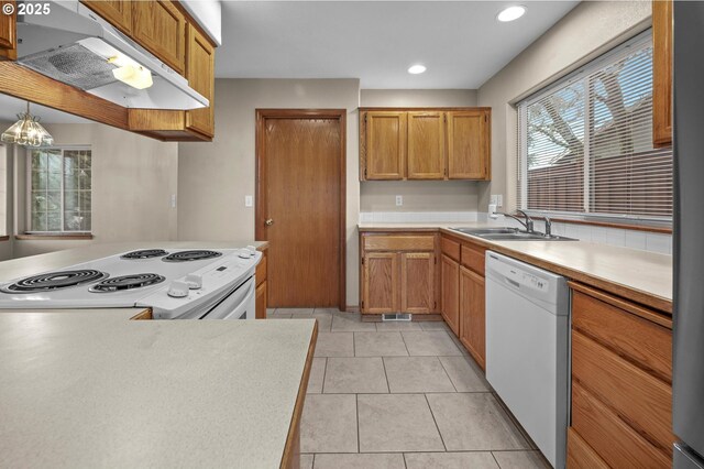 kitchen featuring kitchen peninsula, light tile patterned floors, and white appliances