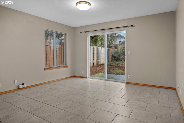 empty room featuring light tile patterned floors and a textured ceiling