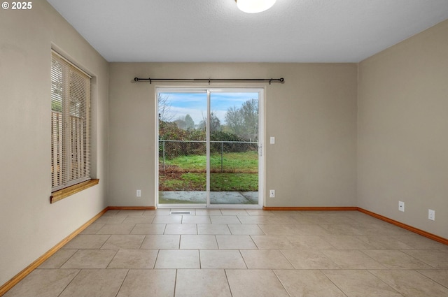 unfurnished room featuring tile patterned floors and baseboards