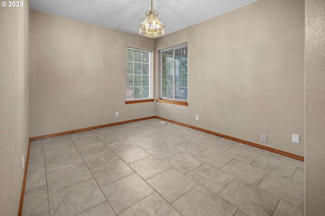 empty room featuring light tile patterned floors and baseboards